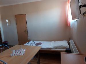 a small room with a bed and a table at Penzion Flipper in Revúca