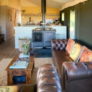 uma sala de estar com um sofá e um fogão em Troney Valley Escapes - Deer's Rest em Crediton