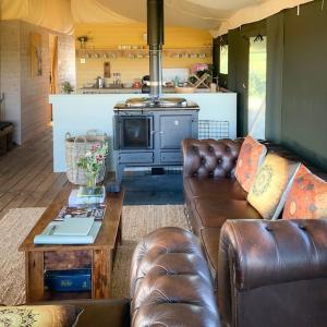 sala de estar con sofá y fogones en Troney Valley Escapes - Owl's Den en Crediton