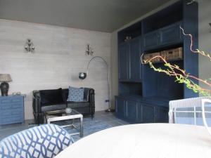 a living room with navy blue cabinets and a couch at Zintuinen in Esbeek