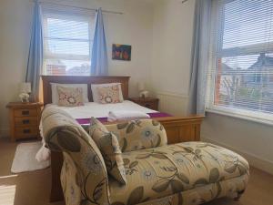 1 dormitorio con 1 cama con silla y sofá en Boardwalk, en Kent