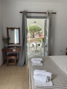 una camera con letto, specchio e tavolo di Kirki Rooms & Studios on the Hill a Paroikia