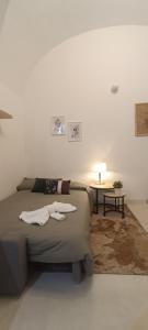 1 dormitorio con 1 cama y 1 mesa con lámpara en Cortile Bellini, en Catania