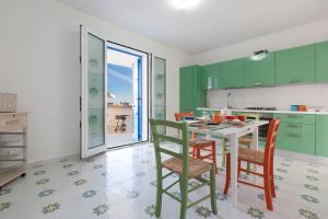 マリーナ・ディ・ペスコルーゼにあるLe Dimore Turchesi by BarbarHouseのキッチン(緑のキャビネット、テーブル、椅子付)
