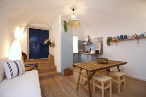 a living room with a table and a kitchen at Terraço do Castelo in Arraiolos