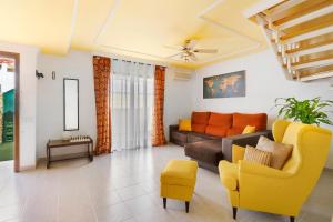 una sala de estar con un sofá y una silla en Colina Verde Maspalomas, en Maspalomas