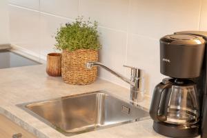 a kitchen counter with a sink and a coffee maker at Levillenet Superior Studios with sauna in Levi