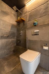 a bathroom with a white toilet in a room at amã Stays & Trails Serendipity, Ranikhet in Rānīkhet +5 photos