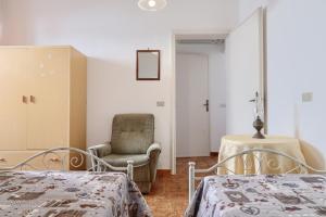 レウカにあるHome Relax Francescaのベッドルーム1室(ベッド2台、椅子、鏡付)