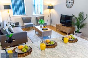 una sala de estar con una mesa con fruta. en Stay Yorkshire Hamilton Mews Apartment en Doncaster