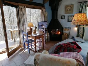 a living room with a desk and a fireplace at Els Pins d'Abella in Camprodon