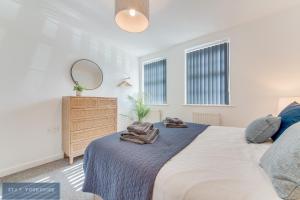 1 dormitorio con cama, espejo y tocador en Stay Yorkshire Hamilton Mews Apartment, en Doncaster