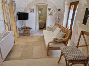 a living room with a couch and a chair at Trullo Siamese in Alberobello