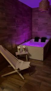 a room with a tub and a chair and a table at Folkowy Dworek SPA & Fun in Murzasichle