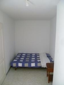 ein kleines Schlafzimmer mit einem blauen und weißen Bett in der Unterkunft Une vue sur la Baume in Sisteron