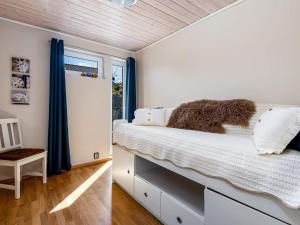 1 dormitorio con 1 cama con cortinas azules y ventana en Holiday home BØMLO en Bømlo