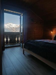 a bedroom with a bed and a window with a mountain view at Portnerhof auf Oberkirn in Schenna