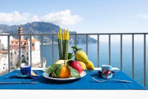 アトラーニにあるLe Tre Sirene Luxury Houseの青いテーブルクロスに果物野菜をかけたテーブル