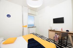 アトラーニにあるLe Tre Sirene Luxury Houseのベッドルーム1室(ベッド1台、デスク、窓付)