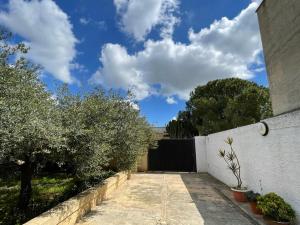 uma entrada que leva a uma casa com árvores e uma cerca em Villetta Calia em Mazara del Vallo