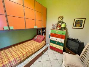 1 dormitorio con 1 cama, TV y vestidor en Villetta Calia, en Mazara del Vallo