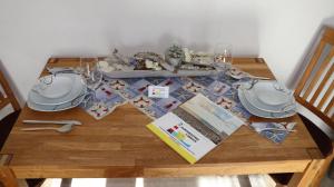 einen Holztisch mit Tischtuch und Weingläsern in der Unterkunft Ferienwohnung Pittermann in Dornumersiel