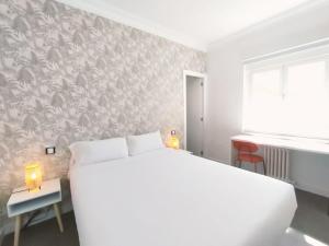 a bedroom with a large white bed and a wall mural at Hostal Gonzala by gaiarooms in Salamanca