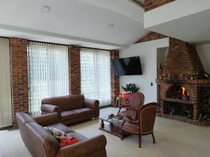 a living room with a couch and a fireplace at HOTEL CABAÑAS SANTO TOMAS in Paipa
