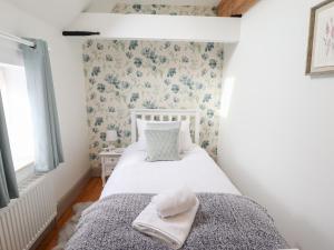 a small bedroom with a bed with a hat on it at Holly Barn in Hull