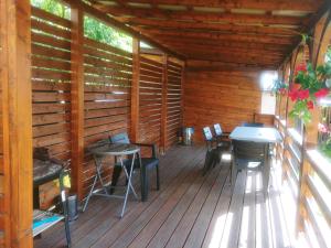 una terraza de madera con mesa y sillas. en Apartament Helenka, en Supraśl