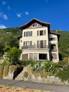 a large house on a hill with stairs in front of it at Reflet Bleu du Lac d'Annecy 3 étoiles - Face au lac, Parking gratuit, Paddle board in Doussard