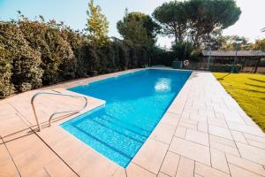 a swimming pool with blue water in a yard at Apartament per parelles reformat amb piscina in Calella de Palafrugell