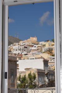 a view of a city from a window at Natal Suites in Ermoupoli