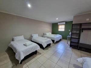 a hotel room with two beds and a tv at Pro Plants Accommodation in Kimberley