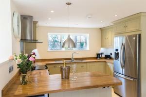a kitchen with a wooden counter and a stainless steel refrigerator at The Old Stables, Derrydown Farm in Andover