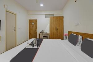 Cette chambre d'hôtel dispose d'un lit avec un service à thé. dans l'établissement Flagship Sri Sai Comforts, à Bangalore