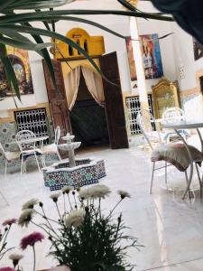ein Zimmer mit Stühlen, einem Tisch und Blumen in der Unterkunft RIAD Dar Ouezzani in Rabat