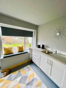 a kitchen with a sink and a window with a sink at The Dairy in Castle Douglas