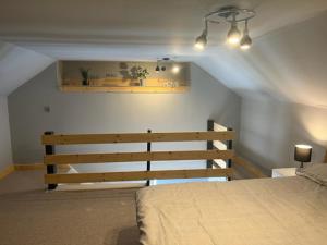 a bedroom with a bed and a bench and lights at The Dairy in Castle Douglas +2 photos