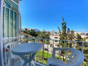 einen Balkon mit einem Tisch und Stühlen sowie Stadtblick in der Unterkunft Ocean View&Fast Wifi Apart in The Heart Of Tangier in Tangier