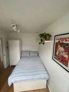 a bedroom with a bed with a striped blanket at Vibrant & Homely 2BD Flat - Angel in London
