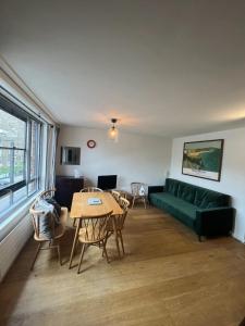 Vibrant & Homely 2BD Flat - Angel في لندن: غرفة معيشة مع أريكة خضراء وطاولة