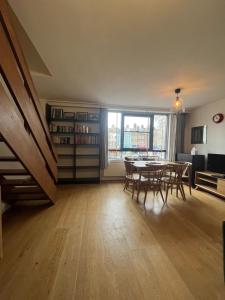 Vibrant & Homely 2BD Flat - Angel في لندن: غرفة معيشة مع طاولة وكراسي وغرفة طعام