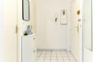 a white bathroom with a mirror and a white tiled floor at Gare Hypercentre - Wifi - Calme - Netflix in Grenoble