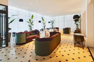 a lobby with couches and chairs in a building at La Licorne Hotel & Spa Troyes MGallery in Troyes