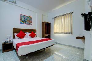 a bedroom with a large bed with red pillows at Varcity Comforts Near Ragigudda Sri Prasanna Anjaneyaswamy Temple in Bangalore