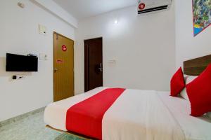 1 dormitorio con 1 cama grande con almohadas rojas en Varcity Comforts Near Ragigudda Sri Prasanna Anjaneyaswamy Temple en Bangalore