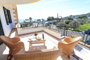 eine Terrasse mit Stühlen, einem Tisch und einem Balkon in der Unterkunft Casa vacanze La Perla a Castro in Castro di Lecce