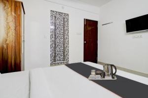 a room with a bed and a door and a window at Flagship Sunshine Inn in Bangalore
