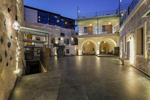 an empty courtyard of a building with a large building at The Niche Cave Hotel in Göreme
